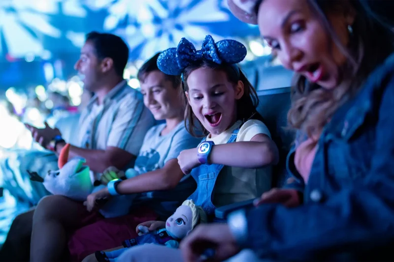 MagicBand+ lighting up during a Disney World theater show. Copyright Disney.