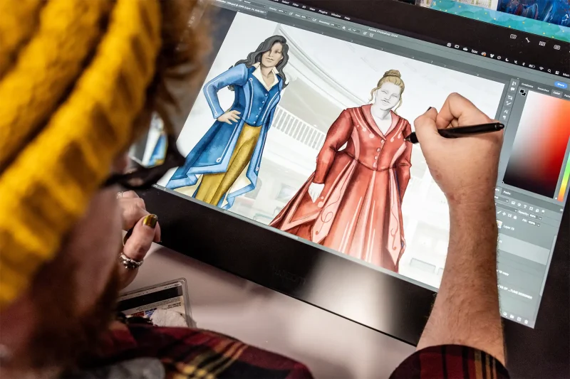 Designer tweakin the Voices of Liberty themed costume designs on a tablet. Copyright Disney.